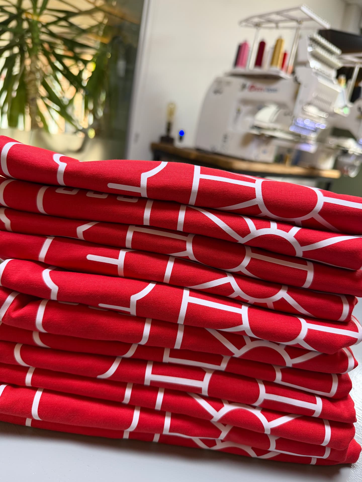 A stack of freshly printed red T-shirts folded and ready